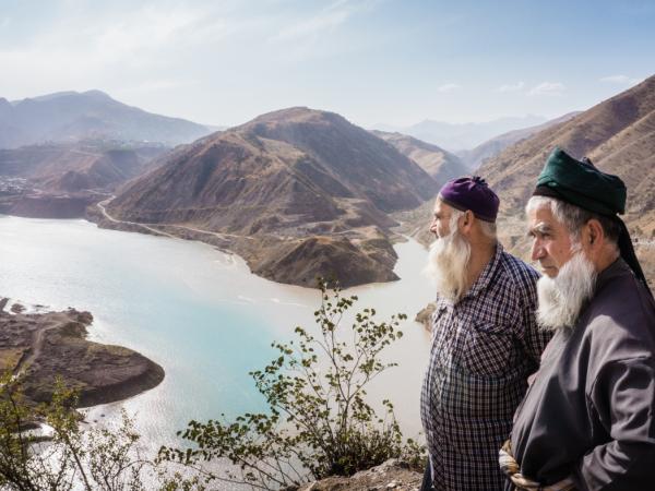 Lokale bewoners met op de achtergrond de bouwsite van Rogun